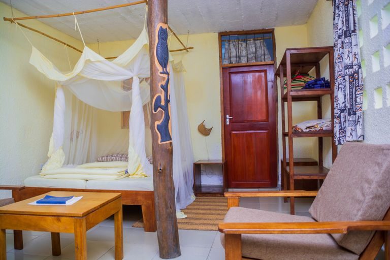 Bed with a mosquito net beside a tall window