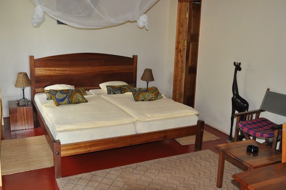 Twin beds under a mosquito net in a lodge room