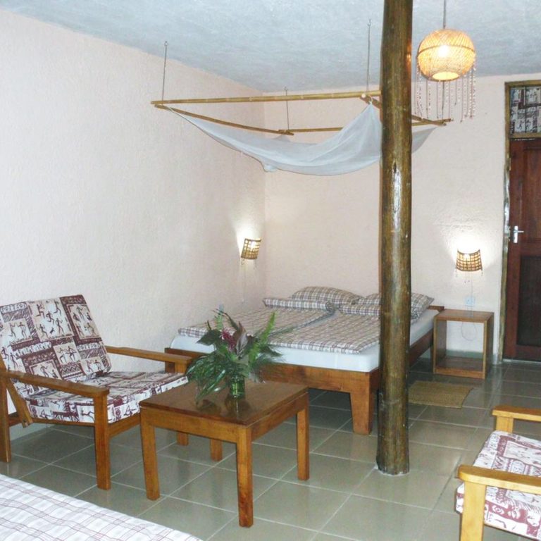 Sitzecke und Bett in einem Standard-Mbega-Zimmer