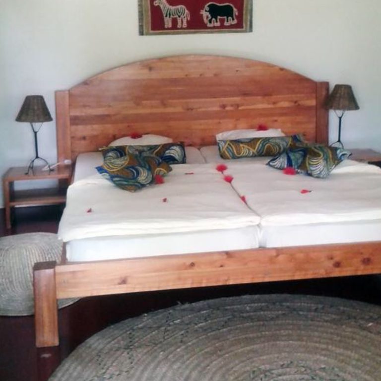 Ein Standard-Simba-Zimmer mit geschnitztem Holzbett